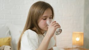 Young girl drinking clean water filtered by Houston water filter system